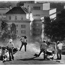 Workers apply tar to the roof of the California State Capitol building as part of the restoration project