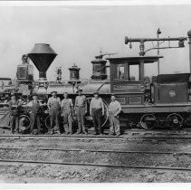 Exterior view of the C. P. Huntington, Engine No. 1 with a group of Southern Pacific employees from the General Shops posing in front of the locomotive