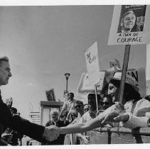 Presidential candidate Eugene McCarthy greets sign-carrying supporters at a rally at the airport