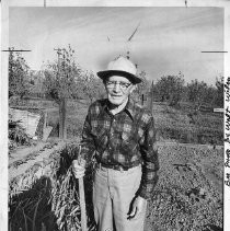 Olivo Massoni, with a hoe on his Hood farm
