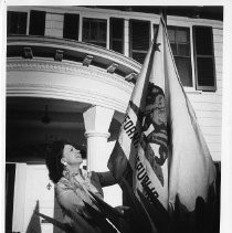 Virginia Carlson Knight, widow of Goodwin Knight, Governor of California from 1953-1959, outside her home with the California state flag