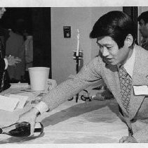 Robert T. (Bob) Matsui pouring wine at a dinner