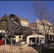 Old Sacramento. View of the Pony Express Statue site at 2nd and J Streets. View shows the site and installation of the statue. Crowd gathers during dedication