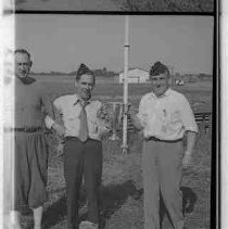 Three men holding a trophy