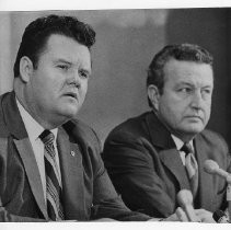 Duane Lowe seated next to John Price, with a bank of microphones