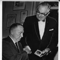 James V. Hicks, Sacramento Police Chief (right) , with Joseph E. Rooney, his top assistant (and later Police Chief), presenting him with a badge