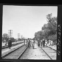 A group of people walking down a railroad track