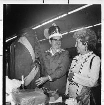 Cy Lemonds, a longtime clerk at Compton's Market on McKinley Blvd., holds his new golf bag at a retirement party thrown by area residents as wife Helen looks on behind a table laden with gifts