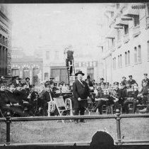 Band seated on lawn in front of R.D. Kimbcough Hardware