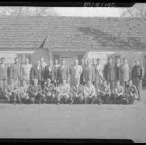 A group of men standing in front of a building
