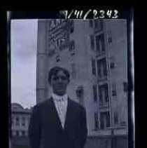 An young man standing next to a multi-story building