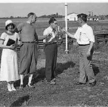 A man holding a trophy with three other people