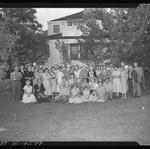 A group of people posed in the yard of a hosue