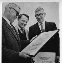 Group view from the left, Donald I Rivett outgoing president of the Sacramento Historic Landmarks Commission receiving a framed resolution for his service from R. Burnett Miller, incoming president. At the right is Eugene Geremia, outgoing vice president