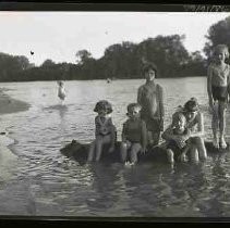 Children standing on a rock in a lake