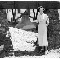 View of a church bell in Butte City. Woman is unidentifed