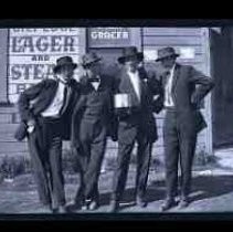 Four men standing outside of a bar