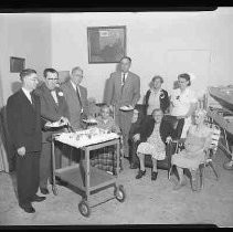 Three elderly women receiving a cake