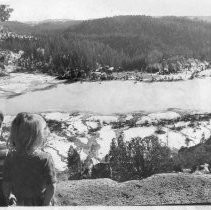 View of the Malakoff Diggings State Historic Park near North Bloomfield in Nevada County. Two youngsters look down on the iced-over pond in the park