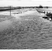 View of Franklin Blvd and the bridge over the Mokelumne River at the Sacramento and San Joaquin county lines during the flood of 1955. On the left is the Western Pacific Railroad trestle