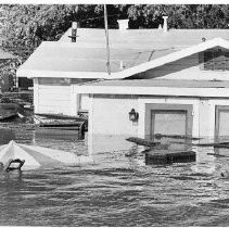 Flood Debris Floats Past Flooded Homes