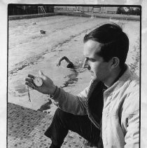 Marty Knight, Swim Coach at Sacramento State University, at pool holding a stopwatch