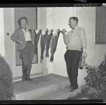 Man and woman with string of fish