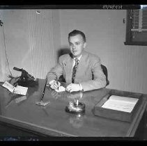 Unidentified man seated at a desk