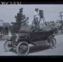 An unidentified men in a car with a motion picure camera