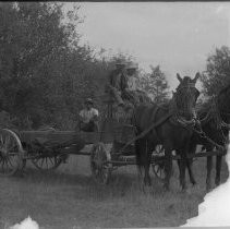 View of three people with a horse-drawn farm wagon