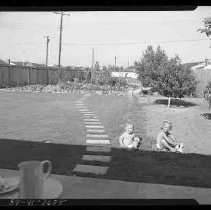 Two children sitting on a lawn