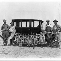 Four men with dear rabbits and a dead hawk