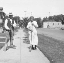 Couple sweeping side walks