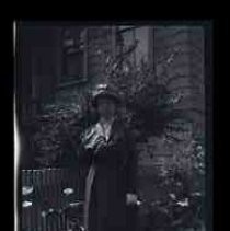 A woman posed in dark suit standing in a yard