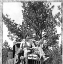 A couple sitting on the hood of an International truck