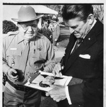 Governor Ronald Reagan autographs a picture for actor Joe Higgins. The two men had just filmed a PSA for the Office of Traffic Safety together