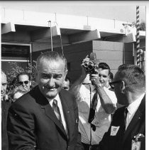 President Lyndon B. Johnson, on a campaign visit to Sacramento, at Aerojet, shaking hands with an employee as a crowd watches and press take pictures