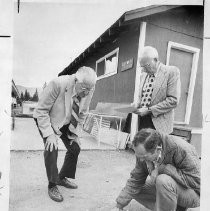 Harold T. "Bizz" Johnson, California state senator (1948-1958) and U.S. Congressman (1958-1981). Here, Jim Brock, Plumas County official, sketches a flood control problem in the dust while Johnson watches and George Campbell takes notes