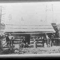 Miners standing in front of a cabin