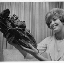 Jeannie M. Langley holds remains of logs that formed the corner of a cabin, perhaps built by a member of the Donner party