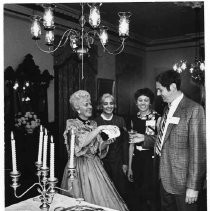 Mrs. Robert Kelley, a hostess for last night's champagne tour of the Stanford Home, pours wine for James Affleck while Donna Affleck observes