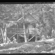 Man on ladder against a cabin