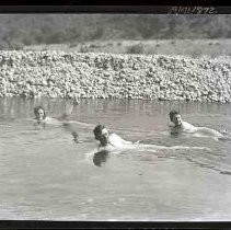 Three people swimming