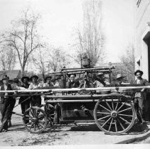 Fire pump with unidentified men gathered around