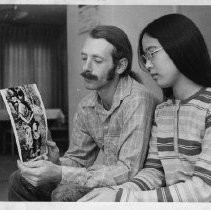 Mr. and Mrs. Stephen Hudson, holding picture of a small child