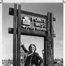 Beverly Garland, actress and motor lodge owner, in front of sign for Point West Motor Lodge