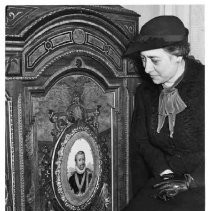 Unidentified woman viewing furniture piece inside Crocker Art Gallery (?)