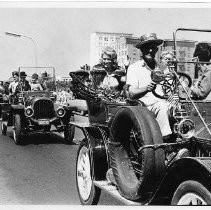 View of a parade down K Street in Sacramento for the California State Fair in 1966 showing antique automobiles carrying dignitaries