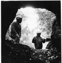 Two men, one with a shovel, inspect a cave near the site of the proposed Auburn Dam