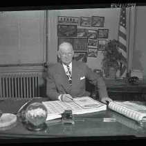 Unidentified man seated at a desk